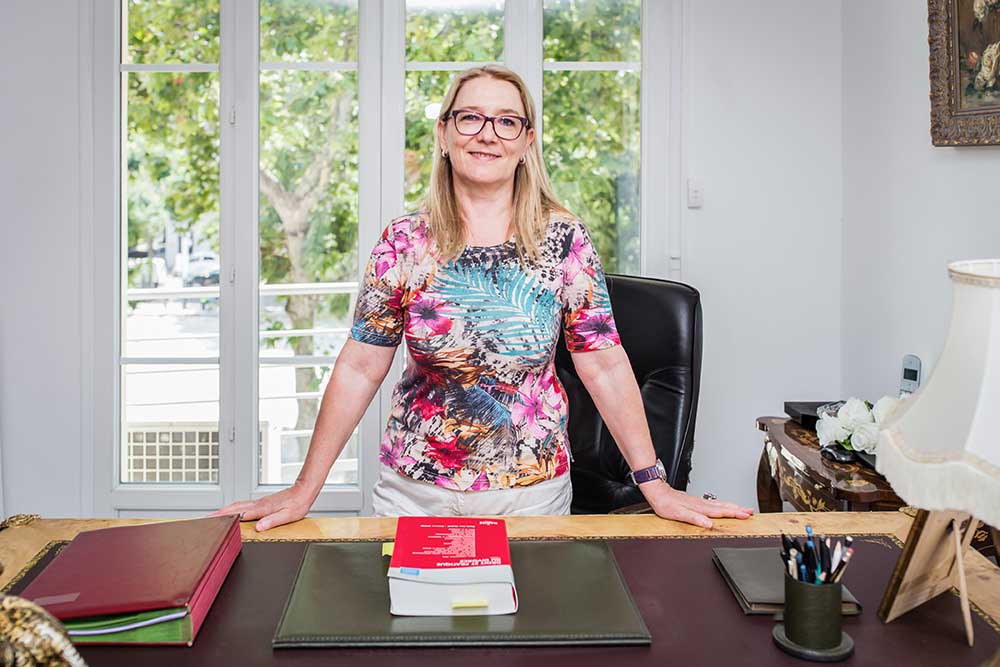 Maître Marianne Piget debout derrière son bureau