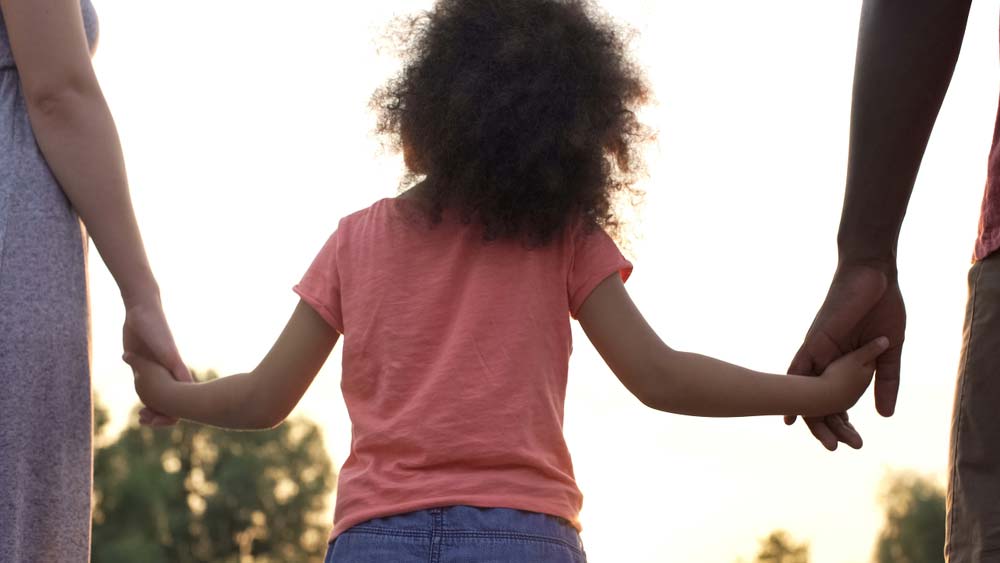 parents tiennent la main de leur enfant